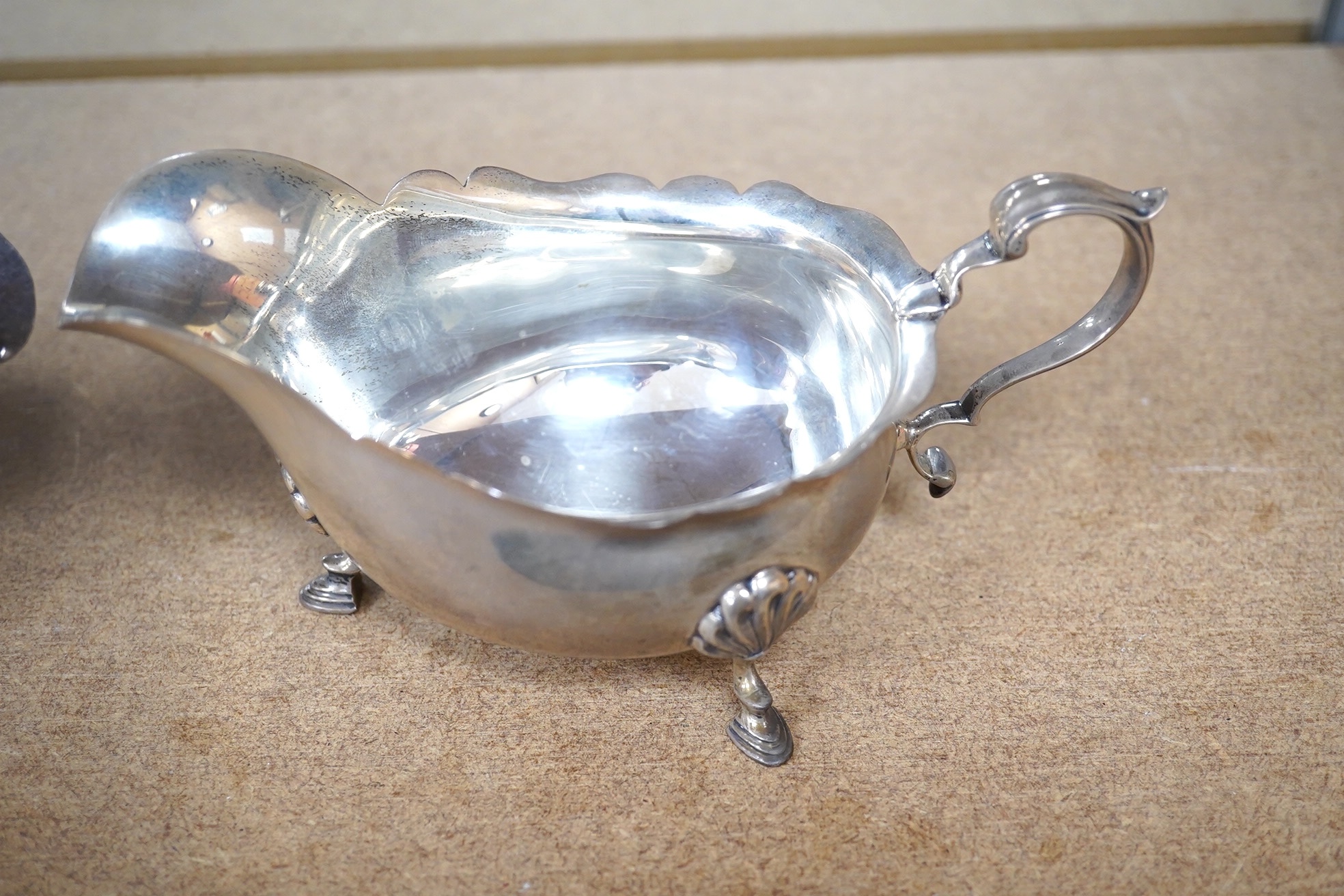 A George II silver sauce boat, London, 1746?, (repair), together with a George V silver sauceboat by Elkington & Co, Birmingham, 1914, 10.5oz. Condition - poor to fair